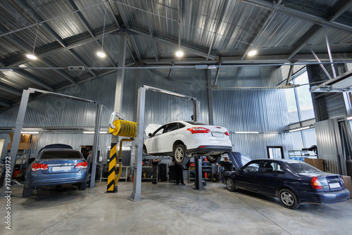 Repair of cars, chassis, automatic transmission and engine in an auto repair shop or garage. The car is lifted on a lift.