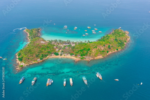 Speedboats and ship around a tropical paradise exotic island in the Indian Pacific Ocean during hopping tour on beach of Asia. View from above top aerial.