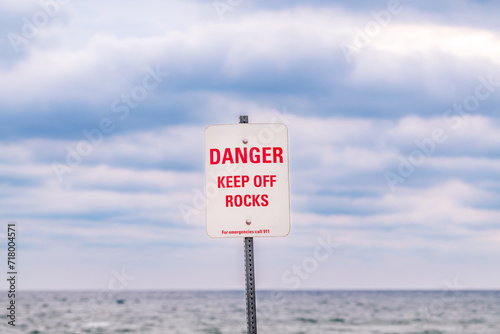Photography danger keep of the rocks for emergencies call 911 signage red letters on dirty w