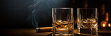 A two glass of whiskey with ice and a Cuban cigar on a wooden table on a dark background. Men's club banner idea. Copy space for text