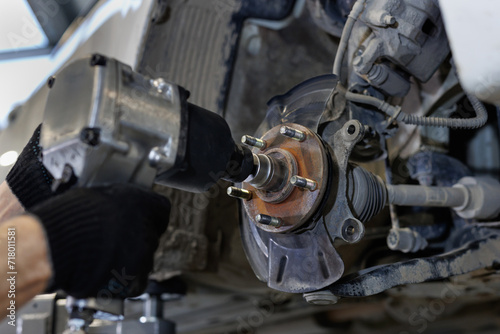 Auto mechanic installing car front brake caliper and brake pads.