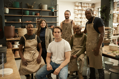 Diverse group of smiling ceramists working in a pottery studio