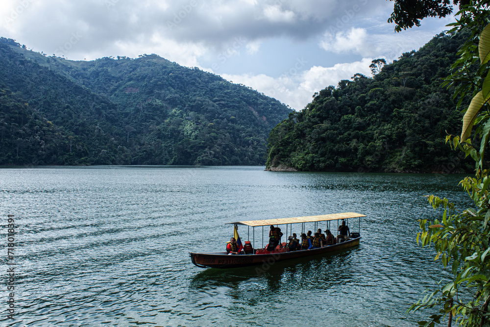boat with tourists on a lake in the middle of mountains and forest on vacation