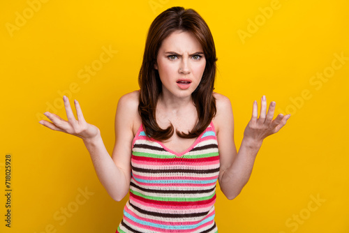 Portrait of dissatisfied offended woman with nose piercing dressed knitwear top raising palms up argue isolated on yellow color background