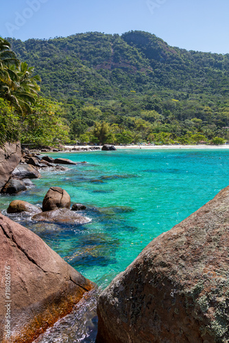 Landscape of Praia do Aventureiro, one of the most paradisiacal beaches in Brazil. Sea with emerald green and turquoise blue tones, during a beautiful sunny day.