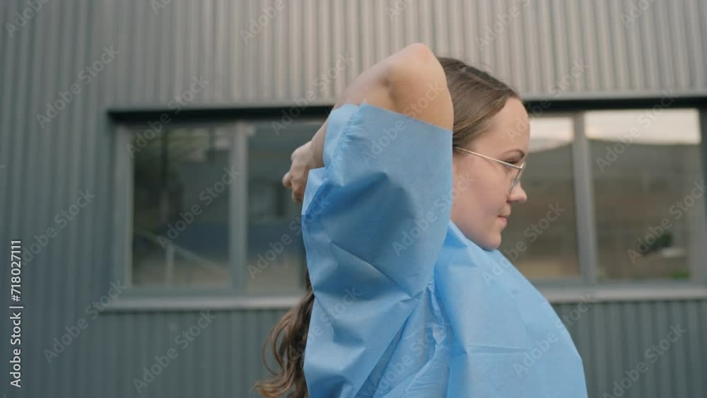 Caucasian woman ties hair in ponytail to prepare for her manual work