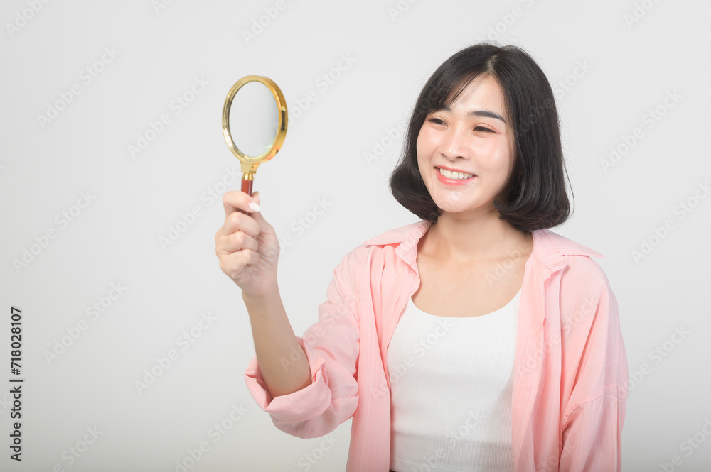 Young asian woman holding magnifying glass over white background, analysis and finance concept. Young asian woman holding magnifying glass over white background, analysis and finance concept.
