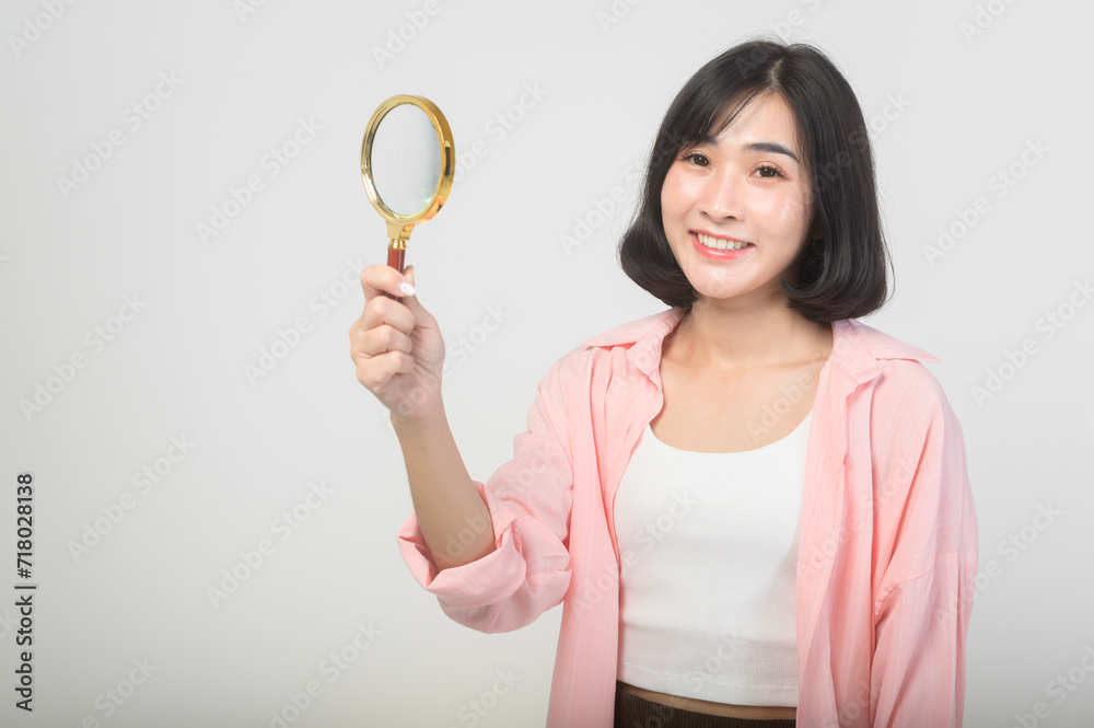 Young asian woman holding magnifying glass over white background, analysis and finance concept. Young asian woman holding magnifying glass over white background, analysis and finance concept.