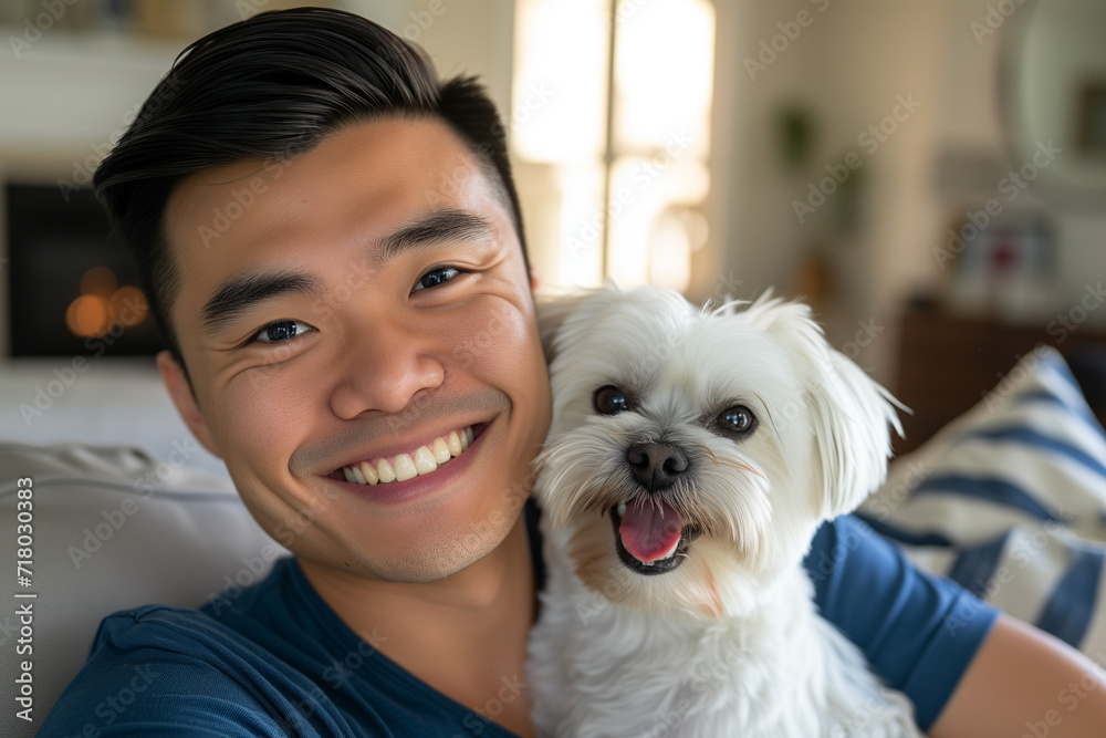 Happy asian man hugging his shih tzu dog in a living room Happy asian man hugging his shih tzu dog in a living room