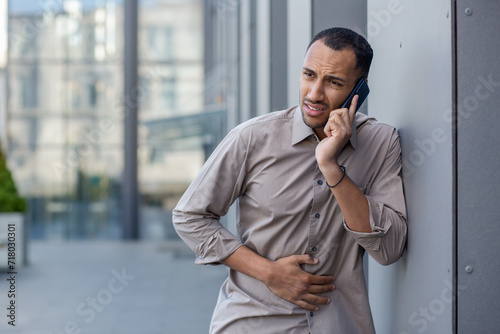 Картината върху платно Sick man outside office building, office worker has severe stomach pain, businessman calls doctor, calls ambulance