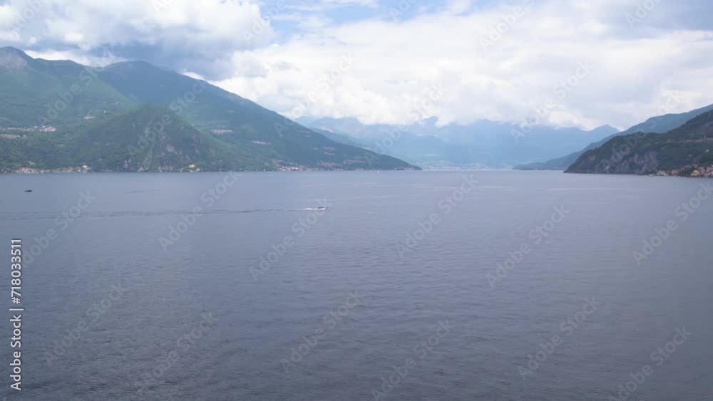 Speedboat chasing over Lake Como surrounded by cloud-covered mountains Speedboat chasing over Lake Como surrounded by cloud-covered mountains