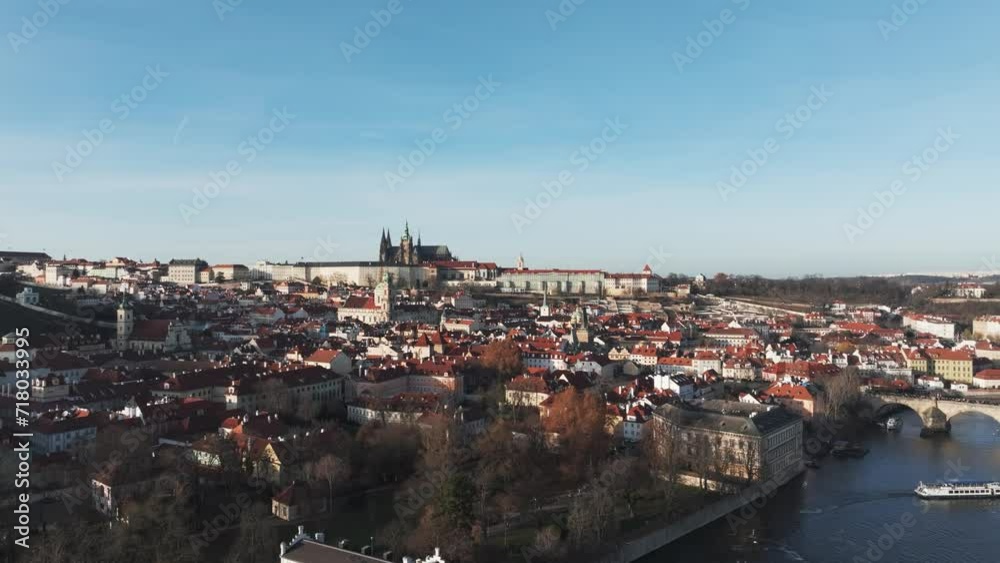 Aerial view of Prague city rooftops and St. Vitus Cathedral in far, blue sky day Aerial view of Prague city rooftops and St. Vitus Cathedral in far, blue sky day