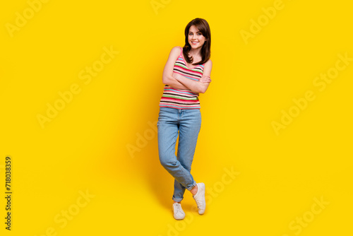 Full size photo of satisfied lovely woman dressed knitwear top jeans pants standing arms crossed isolated on yellow color background