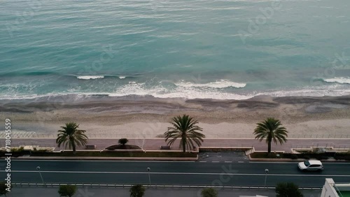 The drone side shot of the sea next to the road with cars passing by in Pietra Ligure