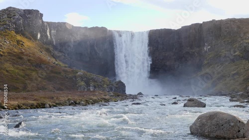 Water falling down over a high waterfall Seydisfjordur i nIceland on a sunny day. photo