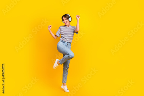 Full body photo of cheerful carefree lady dancing listen music headphones empty space isolated on yellow color background