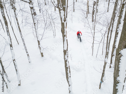 Obraz na płótnie Drone view of a fat biker riding his bicycle in the snow during Canadian winter w salonie