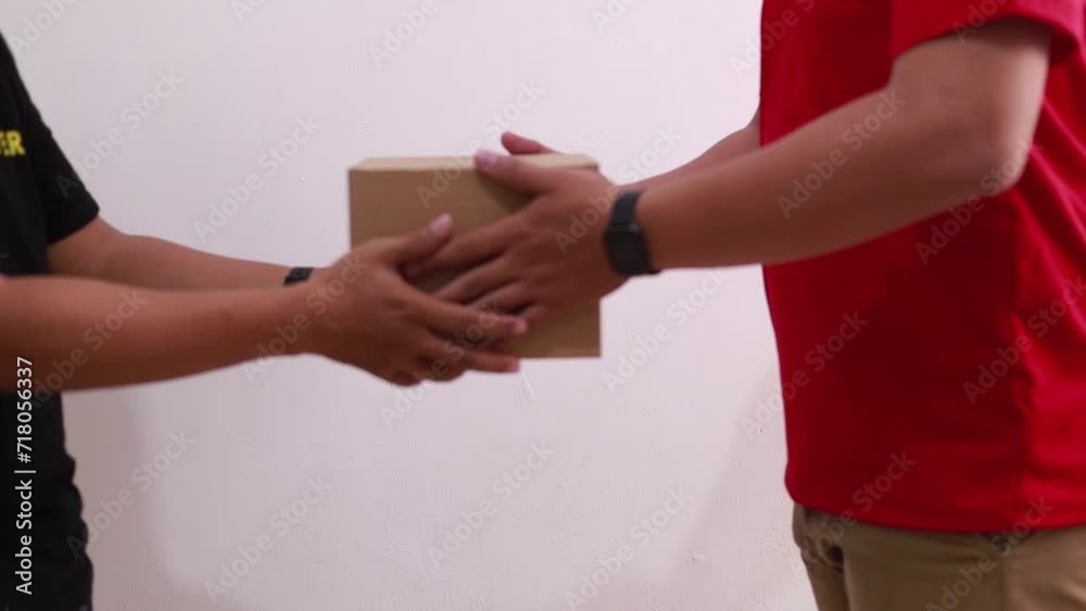 Courier man delivering packet on a cardboard to another man. Close up on hands