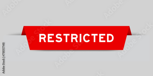 Red color inserted label with word restricted on gray background
