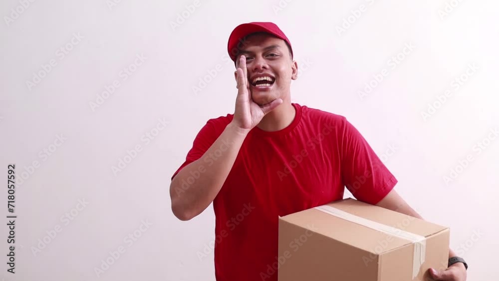Young asian courier man shouting calling while holding cardboard