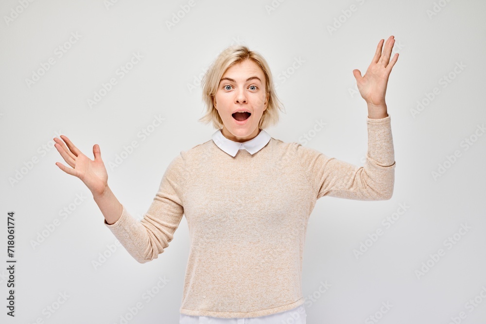 Portrait blond young woman happy face smiling joyfully with raised palms and shocked open mouth isolated on white studio background. Portrait blond young woman happy face smiling joyfully with raised palms and shocked open mouth isolated on white studio background.