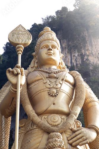 Golden statue of Maruga at Batu Caves during sunrise