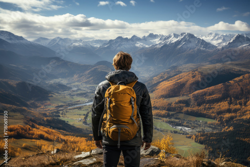 Man with backpack standing on the top of mountain and enjoying the view. Travel concept. Hiking