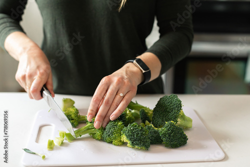 hands chopping broccoli stems for healthy dinner