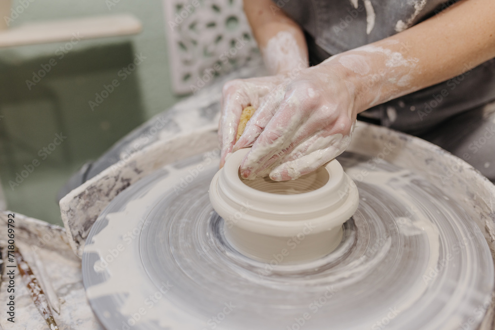 Close up of woman working on pottery at pottery wheel in studio Close up of woman working on pottery at pottery wheel in studio