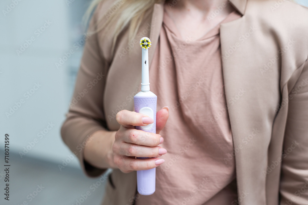 Hand with electric tooth brush on color background