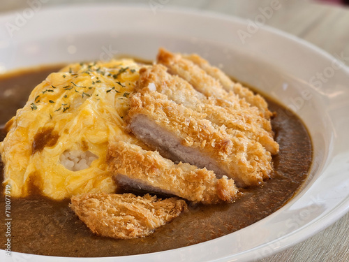 Japanese style deep fried pork with egg omelette curry rice on white plate