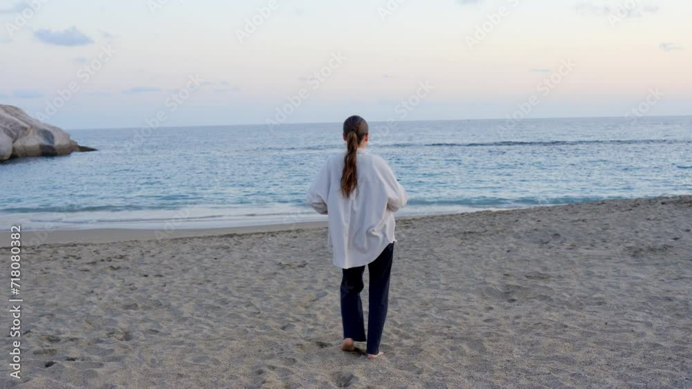 Young girl dancing facing peaceful beach at sunset, rear wide shot, Tenerife Young girl dancing facing peaceful beach at sunset, rear wide shot, Tenerife