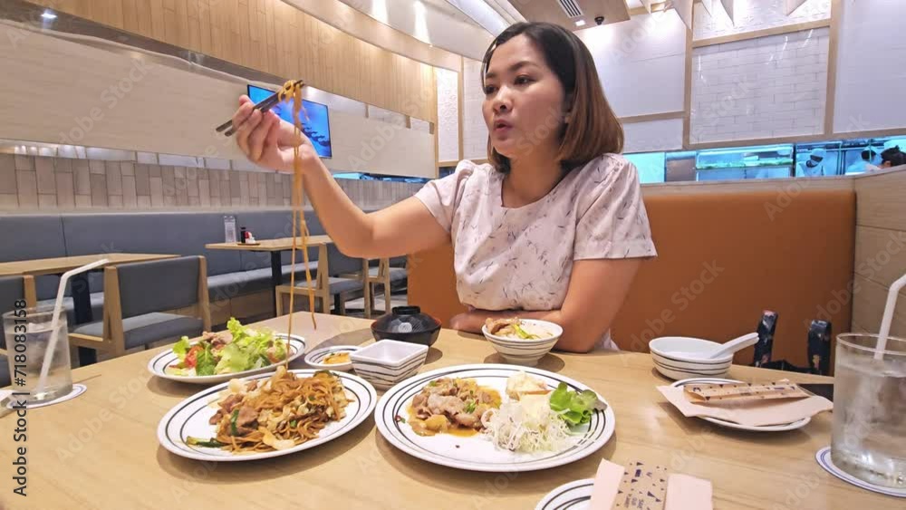 A customer is eating noodles, meat, and some vegetables at a restaurant in Bangkok, Thailand. A customer is eating noodles, meat, and some vegetables at a restaurant in Bangkok, Thailand.