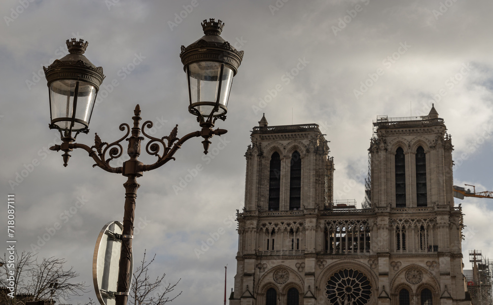 Famous Notre Dame cathedral with Parisian streetlamps in the foreground. UNESCO World Heritage Site, Space for text, selective focus.