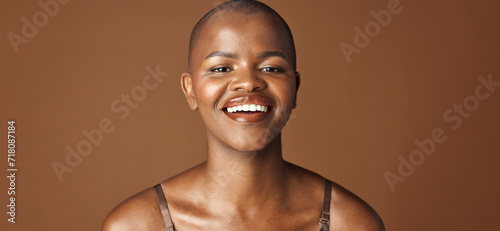 Obraz Face, beauty and smile with happy black woman in studio isolated on brown background for wellness. Portrait, skincare and aesthetic for foundation cosmetics or dermatology with a natural bald person