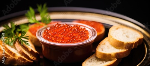 The close-up shot captured the exquisite display of red caviar delicately arranged on a slice of bread, sitting on a pristine white plate. photo