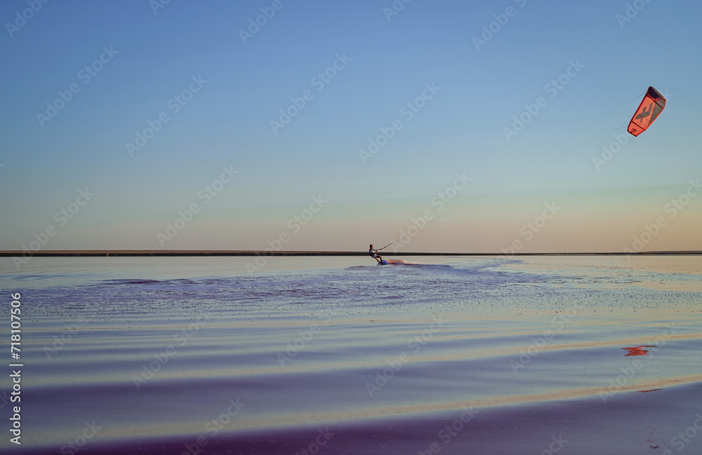 kite surfing on pink lake at sunset