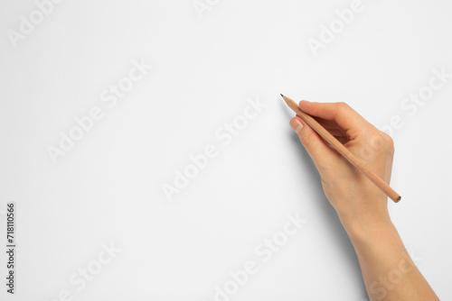 Woman with new graphite pencil on white background, top view. Space for text