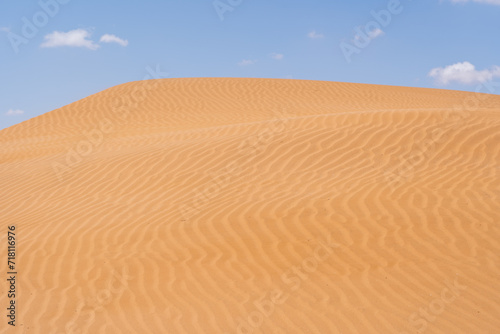 Sand dunes with blue sky and a cloud in Morocco. High quality photo
