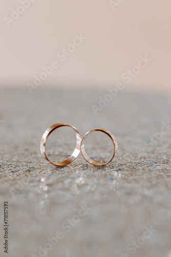 Gold wedding rings in a macro shot. Blurred background. Details. Elegant wedding rings for the bride and groom with highlights, selective focus