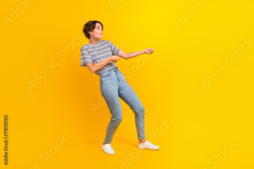 Full length profile photo of focused hardworking person biting lips arms pull empty space isolated on yellow color background
