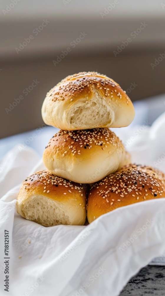 A stack of buns sitting on top of a white napkin. A stack of buns sitting on top of a white napkin.