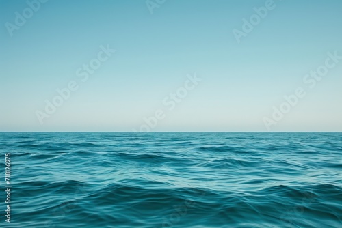 a flat and smooth water wave with blue sky over it