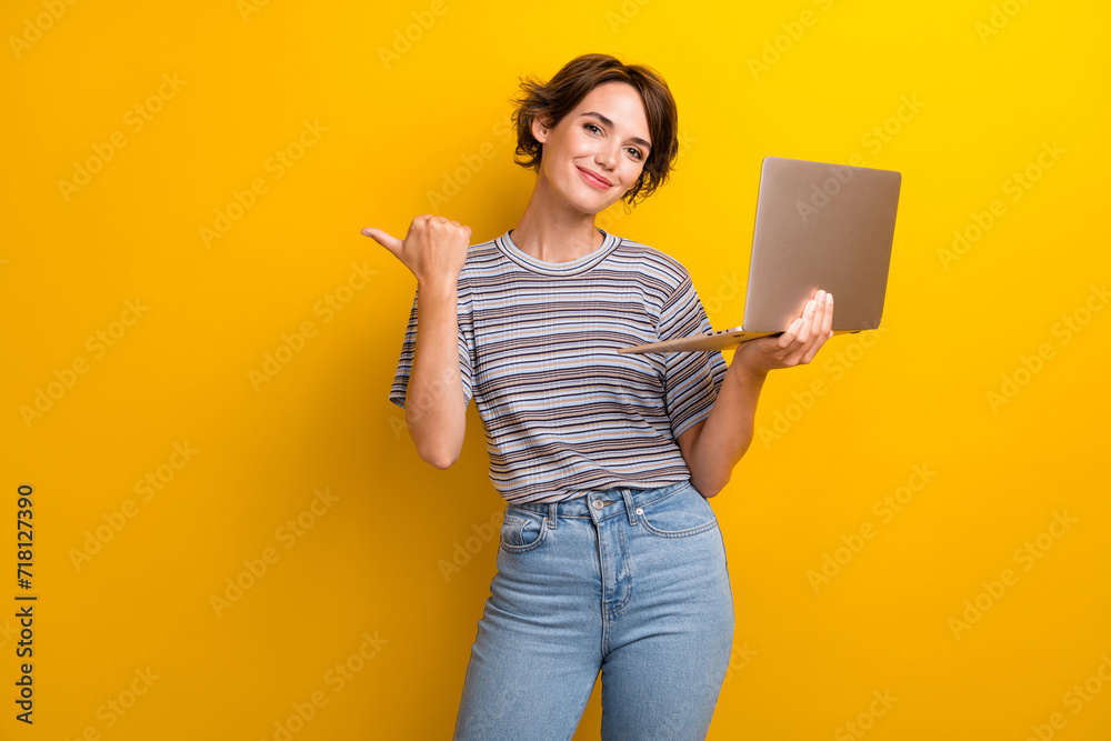Photo of gorgeous woman with bob hairdo dressed t-shirt hold laptop directing at offer empty space isolated on yellow color background Photo of gorgeous woman with bob hairdo dressed t-shirt hold laptop directing at offer empty space isolated on yellow color background