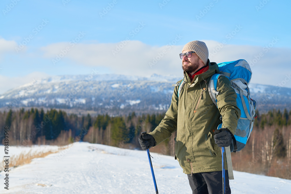 Free bearded traveler enjoying beauty of mountains and contemplating nature in winter