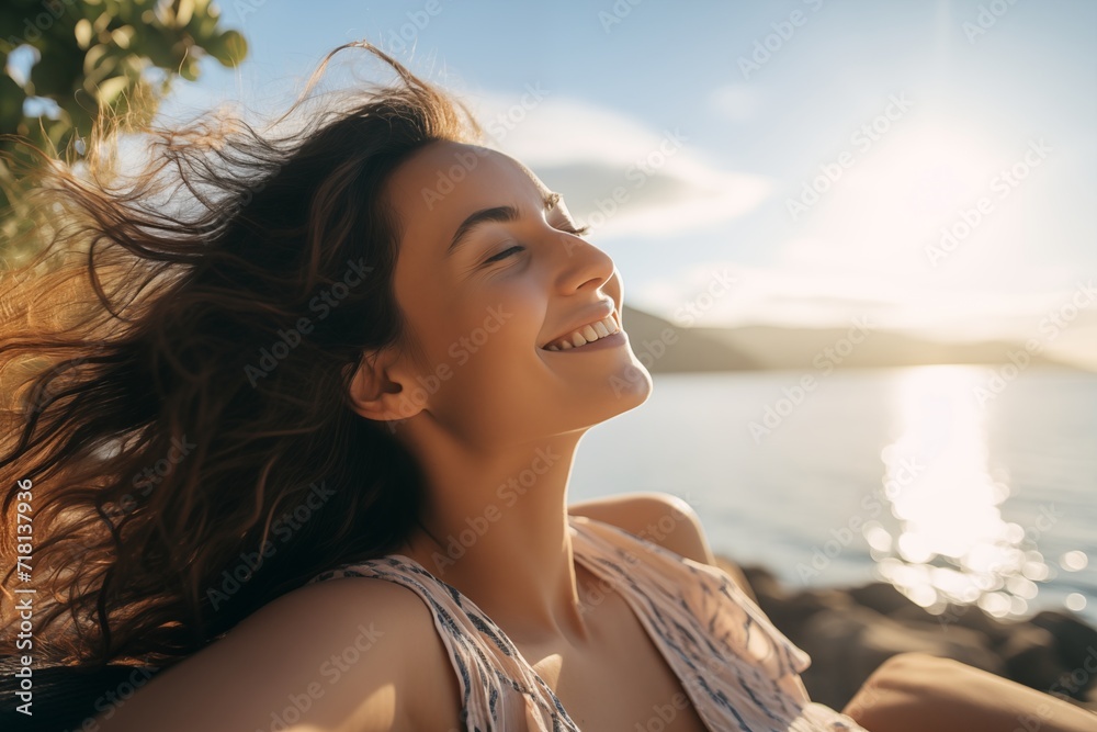 A woman smiles brightly, lying in a bed, exuding happiness and comfort in the morning light.
