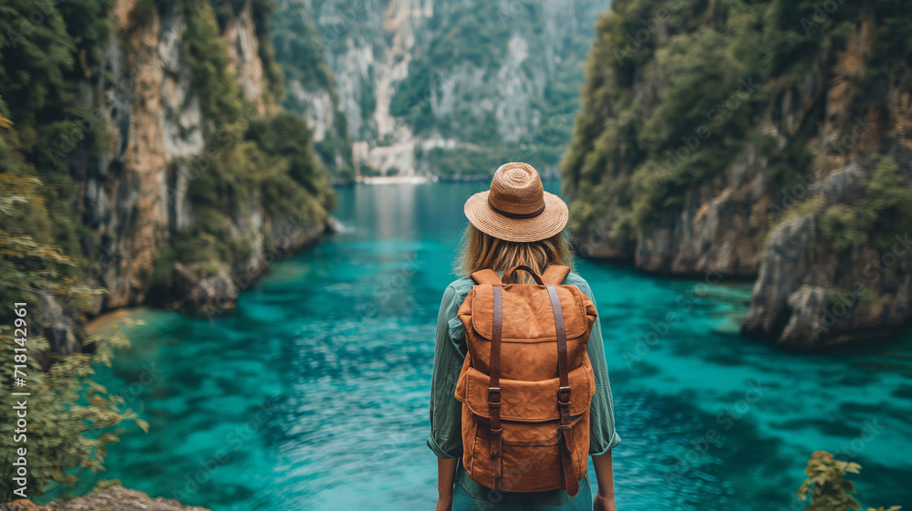 Travel image. Traveler look on the mountain lake. Travel and active life concept. Adventure and travel in the mountains. Woman traveler wearing hat and looking at amazing mountains and lake.