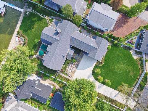 Aerial View of Luxurious Suburban Homes with Lush Gardens and Waterfront