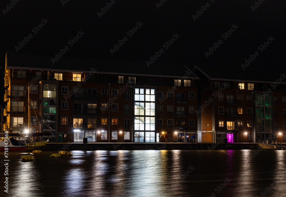 Illuminated Quayside Apartments Across The Quay At The Historic Docks At Gloucester At Night In Winter