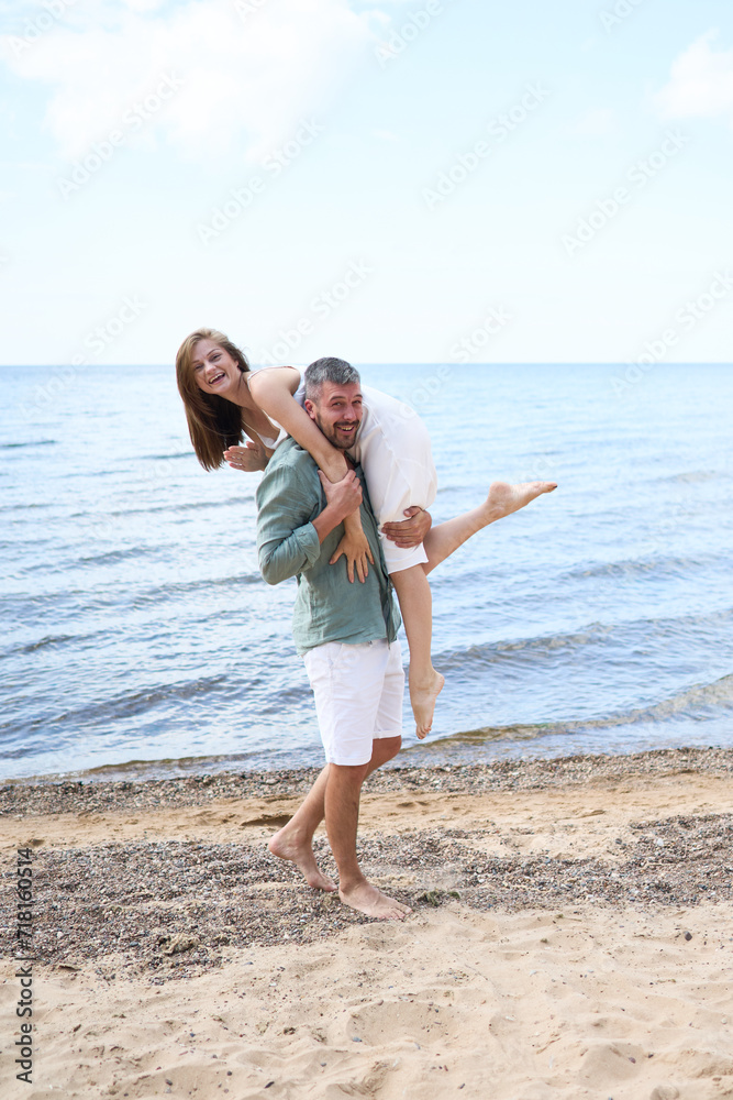 A vertical closeup of a happy caucasian pair hugging each other on the Baltic sea